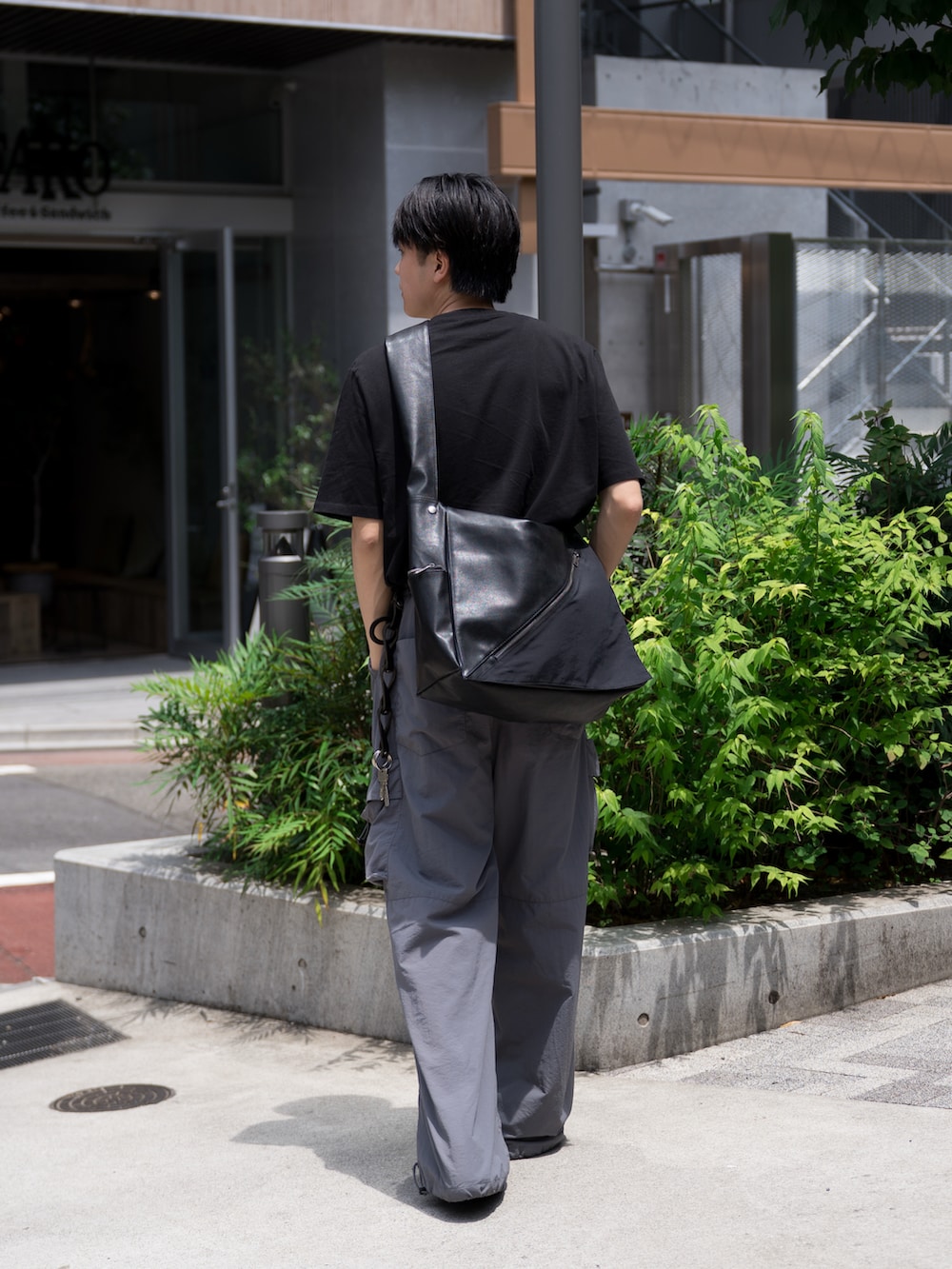 「ショルダーバッグ、夏コーデ、ワイドパンツ、カーゴパンツ、PUMA、黒Tシャツ、タックイン、シンプル、初夏コーデ、カジュアルコーデ」｜「WYM LIDNMのEXTRA FINE COTTON BASIC TEE -SLIM CROPPED FIT-（Tシャツ/カットソー、ブラック系）」を使った、KAIさん（メンズ・183cm）の春コーディネートの2枚目の写真