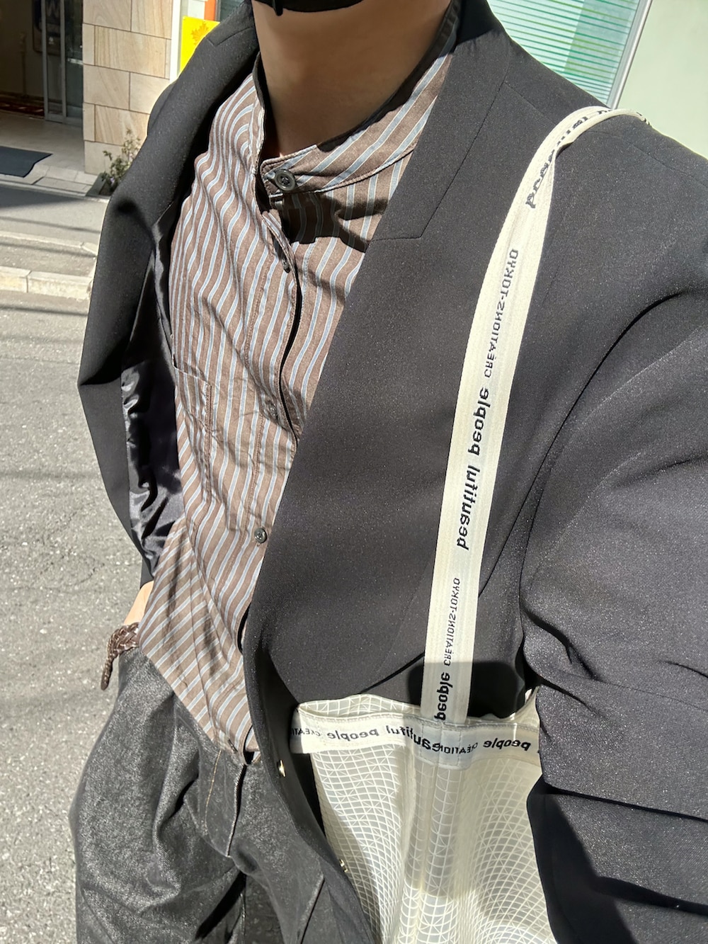 ブラック系のテーラードジャケット、ブラウン系のシャツ/ブラウス、ブラック系のデニムパンツを着用したメンズの春コーディネートの3枚目の写真