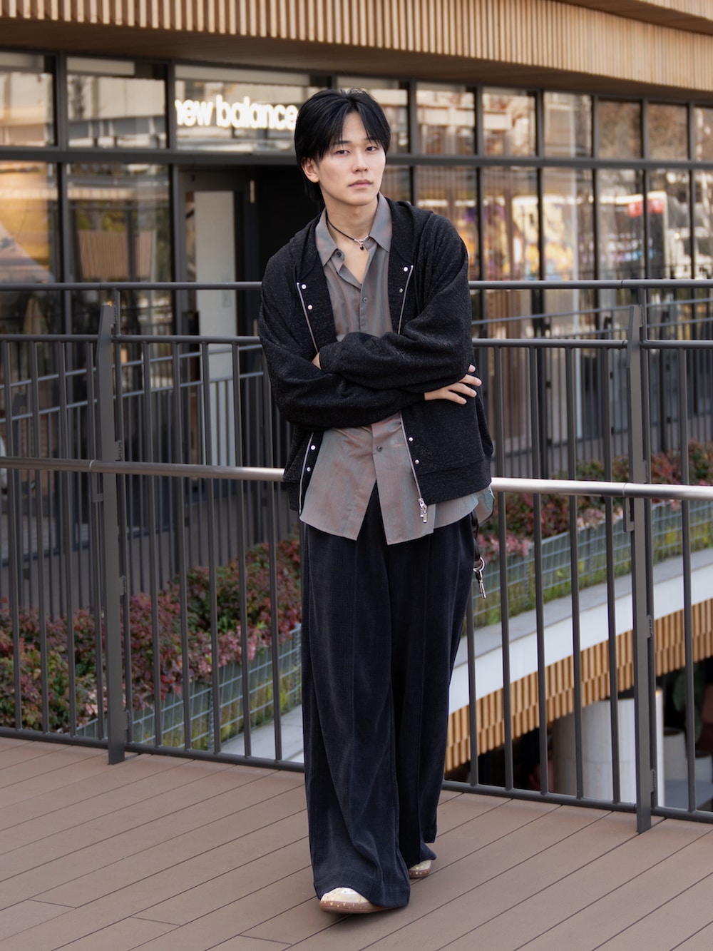 オレンジ系のシャツ/ブラウス、グレー系のスラックス、ブラック系のパーカーを着用したメンズの冬コーディネートの2枚目の写真