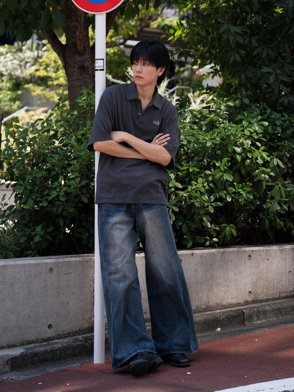 グレー系のビジネスシャツ、ブルー系のデニムパンツ、ブラック系のローファーを着用したメンズの夏コーディネートの2枚目の写真