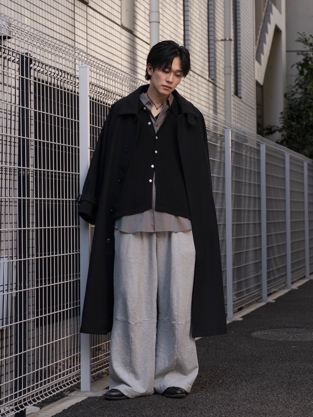 オレンジ系のシャツ/ブラウス、ブラック系のステンカラーコート、ブラック系のローファーを着用したメンズの冬コーディネートの2枚目の写真