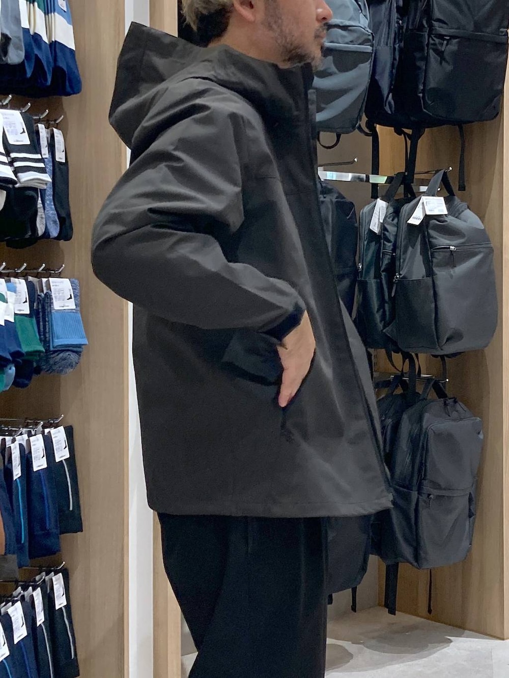 グリーン系のマウンテンパーカー、ホワイト系のTシャツ/カットソー、ブラック系のバックパック/リュックを着用したメンズの秋コーディネートの5枚目の写真