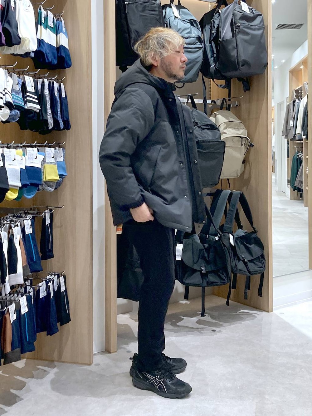 グレー系のダウンジャケット/コート、グレー系のニット/セーター、ブラック系のその他パンツを着用したメンズの秋コーディネートの2枚目の写真