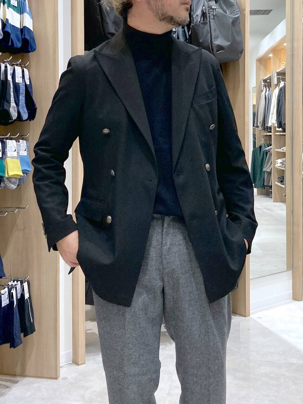 ブラック系のテーラードジャケット、グレー系のスラックス、ブラック系のニット/セーターを着用したメンズの冬コーディネートの5枚目の写真