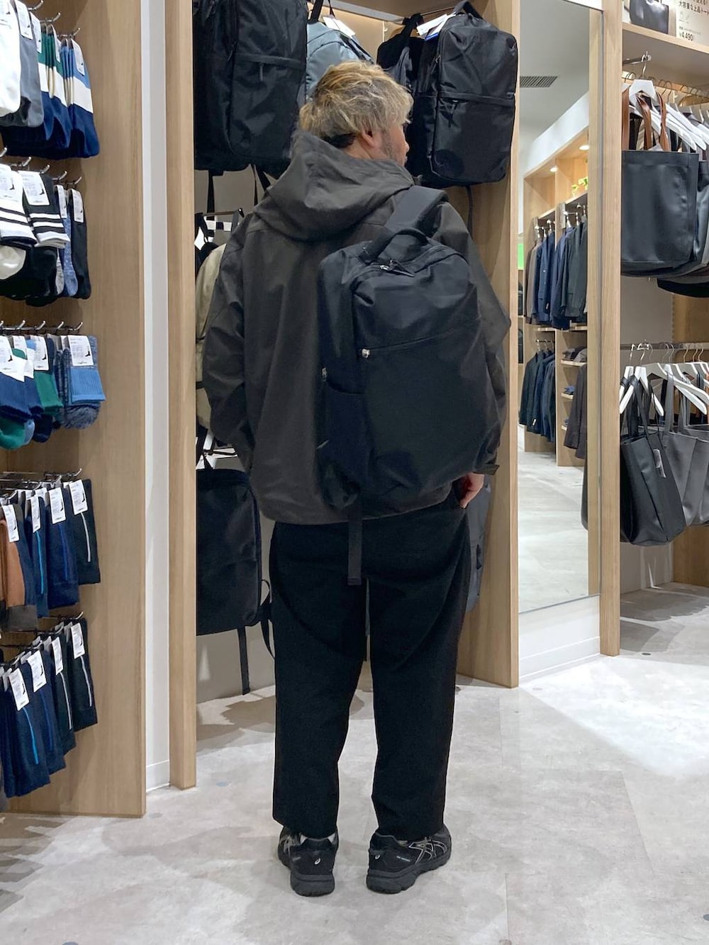 グリーン系のマウンテンパーカー、ホワイト系のTシャツ/カットソー、ブラック系のバックパック/リュックを着用したメンズの秋コーディネートの3枚目の写真