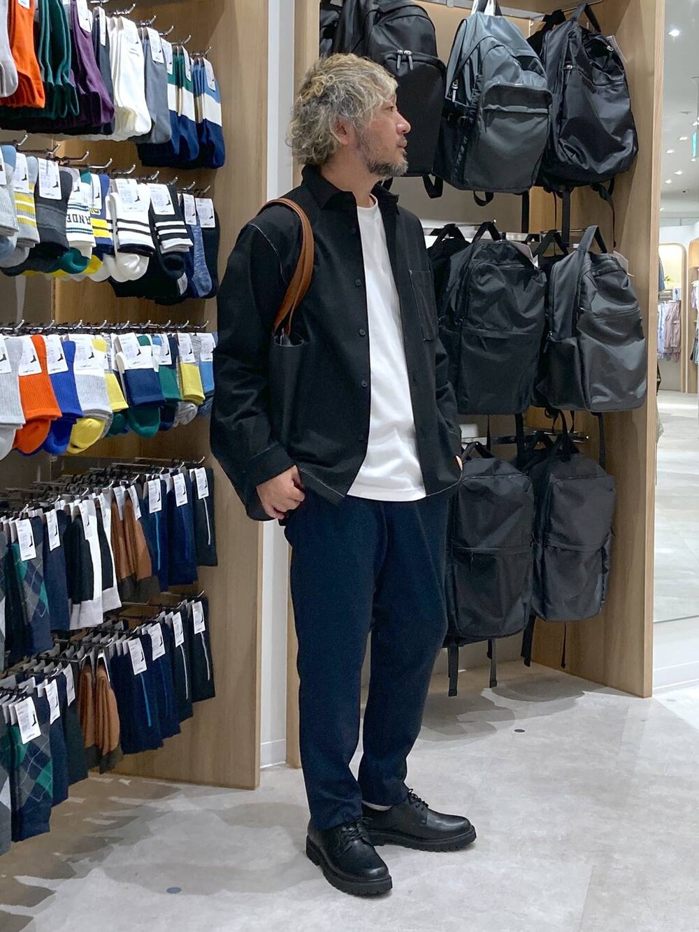 ホワイト系のTシャツ/カットソー、ブラック系のトートバッグ、ブルー系のスラックスを着用したメンズの秋コーディネートの2枚目の写真