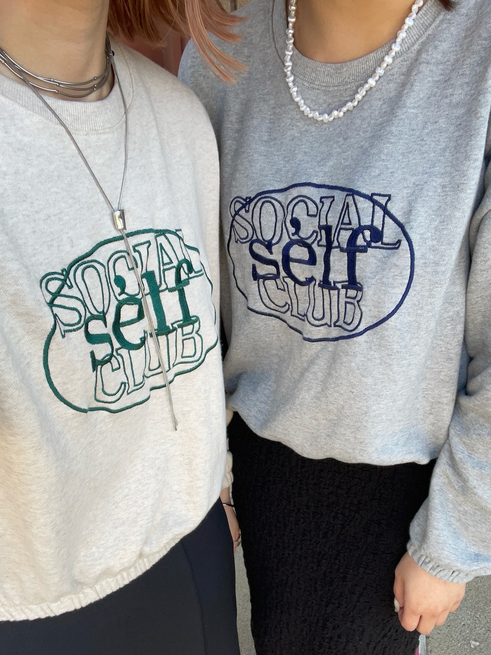 ブラック系のスカート、ホワイト系のスニーカー、ホワイト系のトートバッグを着用したレディースの春コーディネートの2枚目の写真