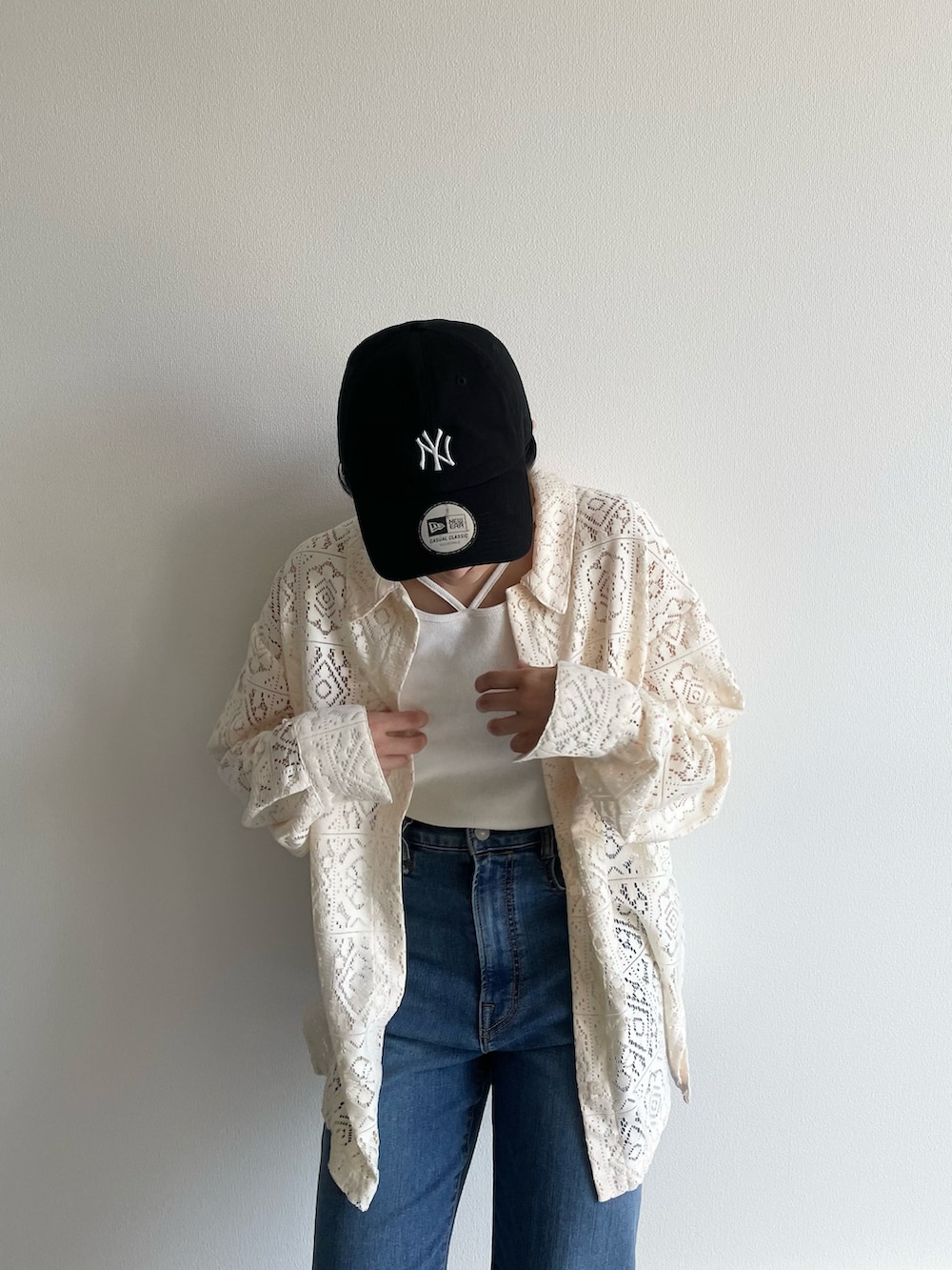 ホワイト系のシャツ/ブラウス、ホワイト系のタンクトップ、ブルー系のデニムパンツを着用したレディースの春コーディネートの2枚目の写真