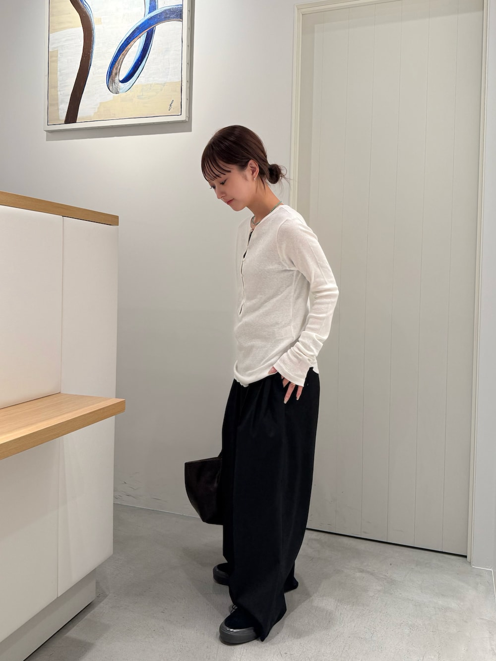 ブラウン系のトートバッグ、ホワイト系のTシャツ/カットソーを着用したレディースの夏コーディネートの2枚目の写真