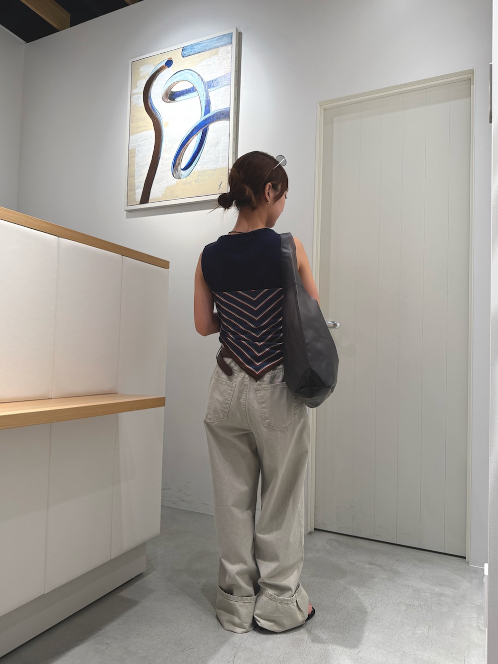 ベージュ系のその他パンツ、ブラック系のショルダーバッグ、ブルー系のニット/セーターを着用したレディースの夏コーディネートの3枚目の写真