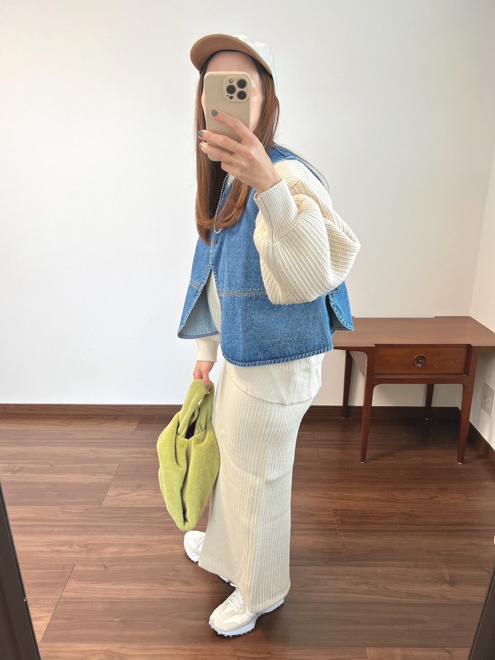 ブルー系のベスト、ホワイト系のニット/セーター、ホワイト系のスカートを着用したレディースの秋コーディネートの2枚目の写真