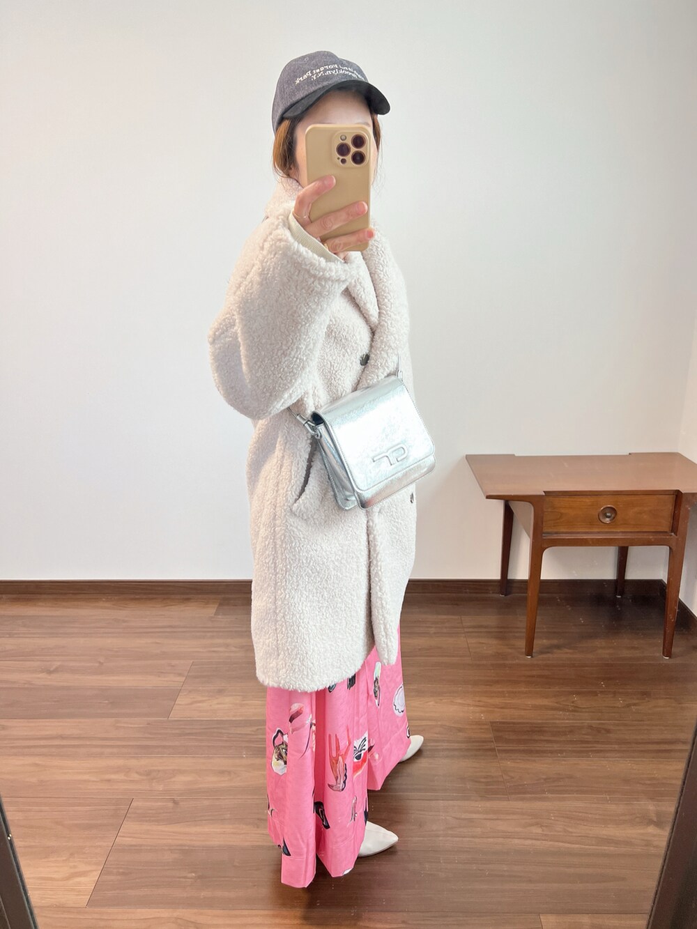 ベージュ系のその他アウター、ピンク系のスカート、ホワイト系のブーツを着用したレディースの冬コーディネートの2枚目の写真