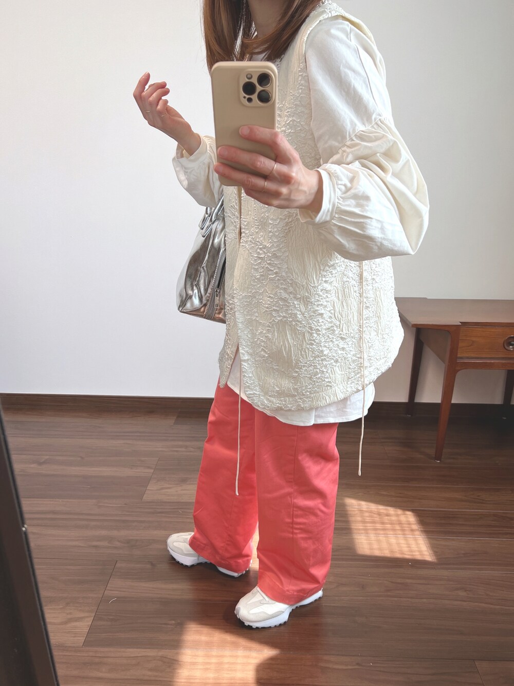 ホワイト系のベスト、ホワイト系のTシャツ/カットソー、ピンク系のチノパンツを着用したレディースの春コーディネートの2枚目の写真