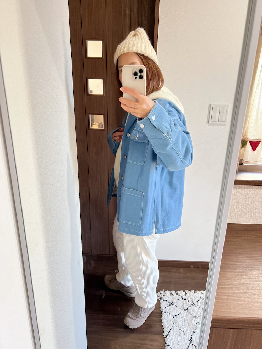 ホワイト系のニット/セーター、ブルー系のその他アウター、イエロー系のショルダーバッグを着用したレディースの冬コーディネートの2枚目の写真