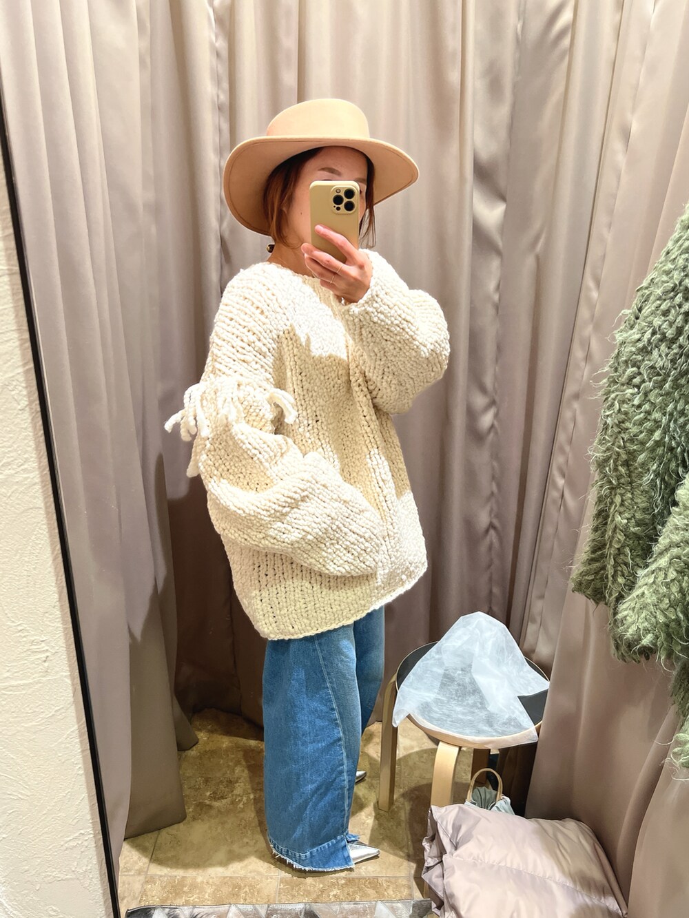 ホワイト系のニット/セーター、ブルー系のデニムパンツ、シルバー系のブーツを着用したレディースの冬コーディネートの2枚目の写真