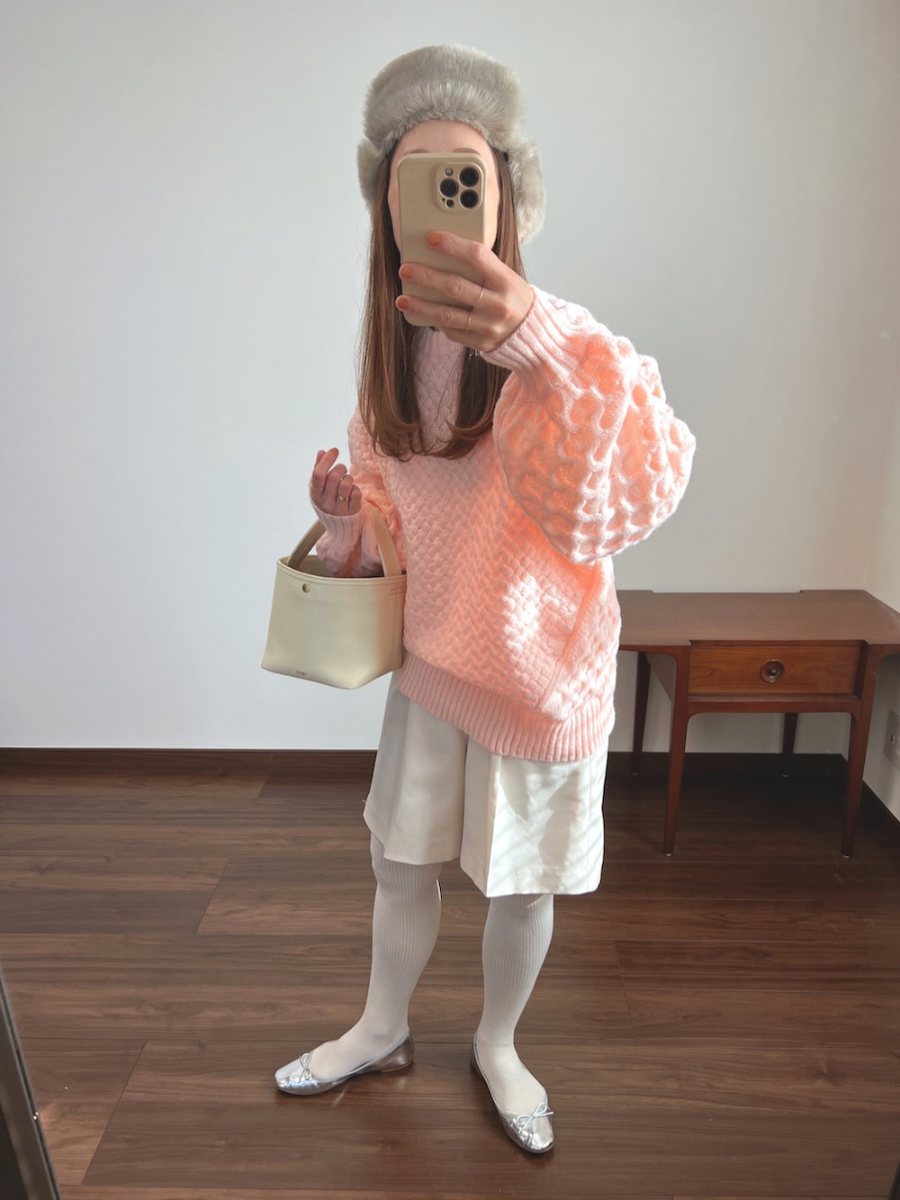 ピンク系のニット/セーター、ベージュ系のスラックス、シルバー系のバレエシューズを着用したレディースの冬コーディネートの2枚目の写真