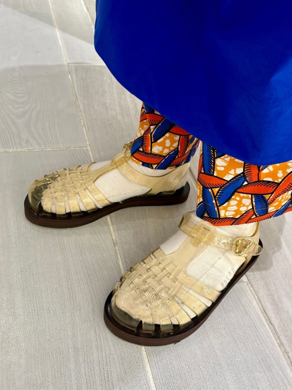 ブルー系のワンピース、オレンジ系のその他パンツ、ベージュ系のショルダーバッグを着用したレディースの春コーディネートの2枚目の写真