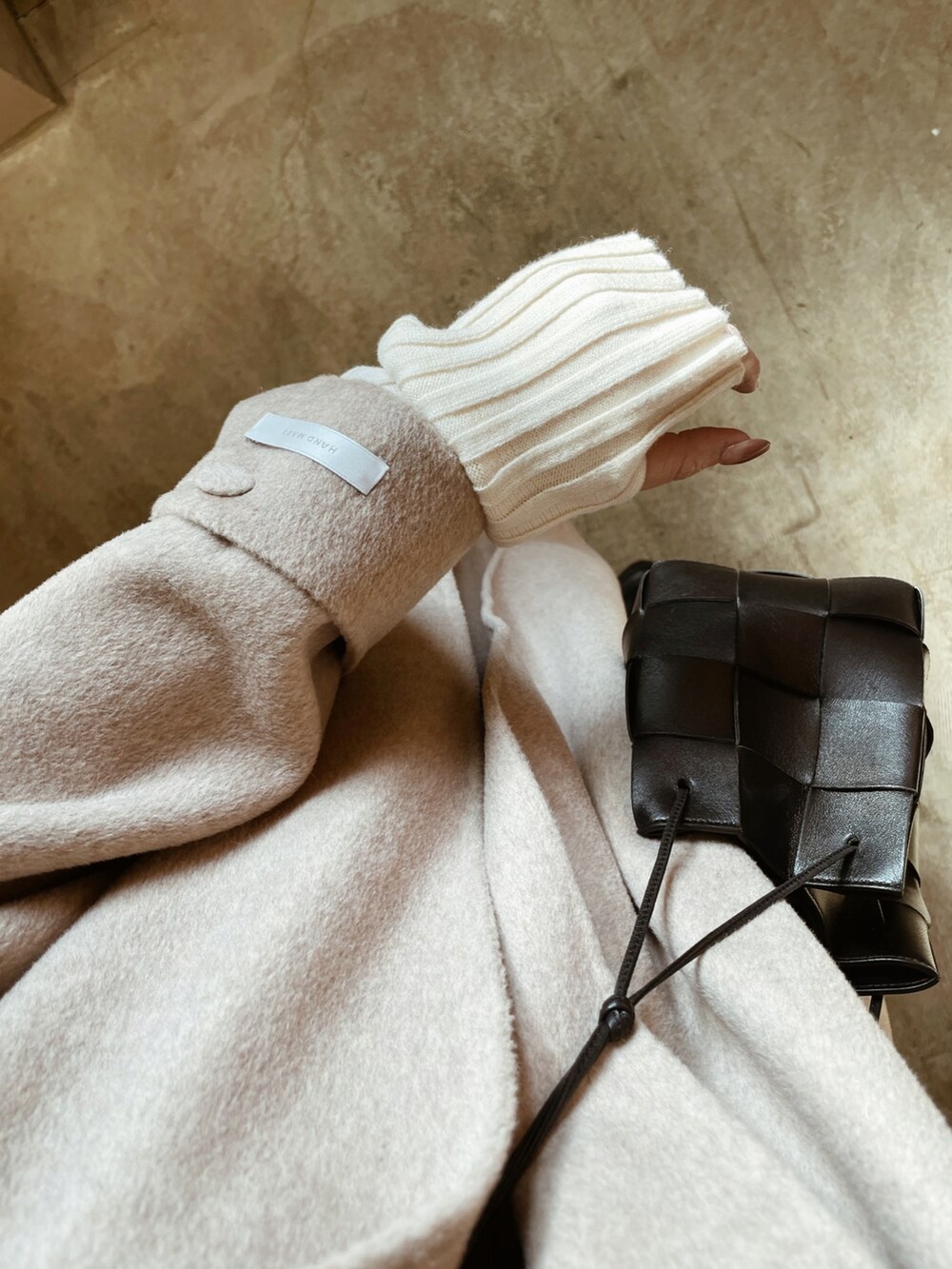 その他のチェスターコート、ブラック系のバッグ、ブルー系のデニムパンツを着用したレディースの冬コーディネートの4枚目の写真