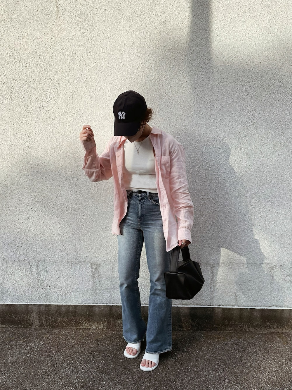 ブルー系のデニムパンツ、ホワイト系のサンダル、ピンク系のシャツ/ブラウスを着用したレディースの夏コーディネートの4枚目の写真