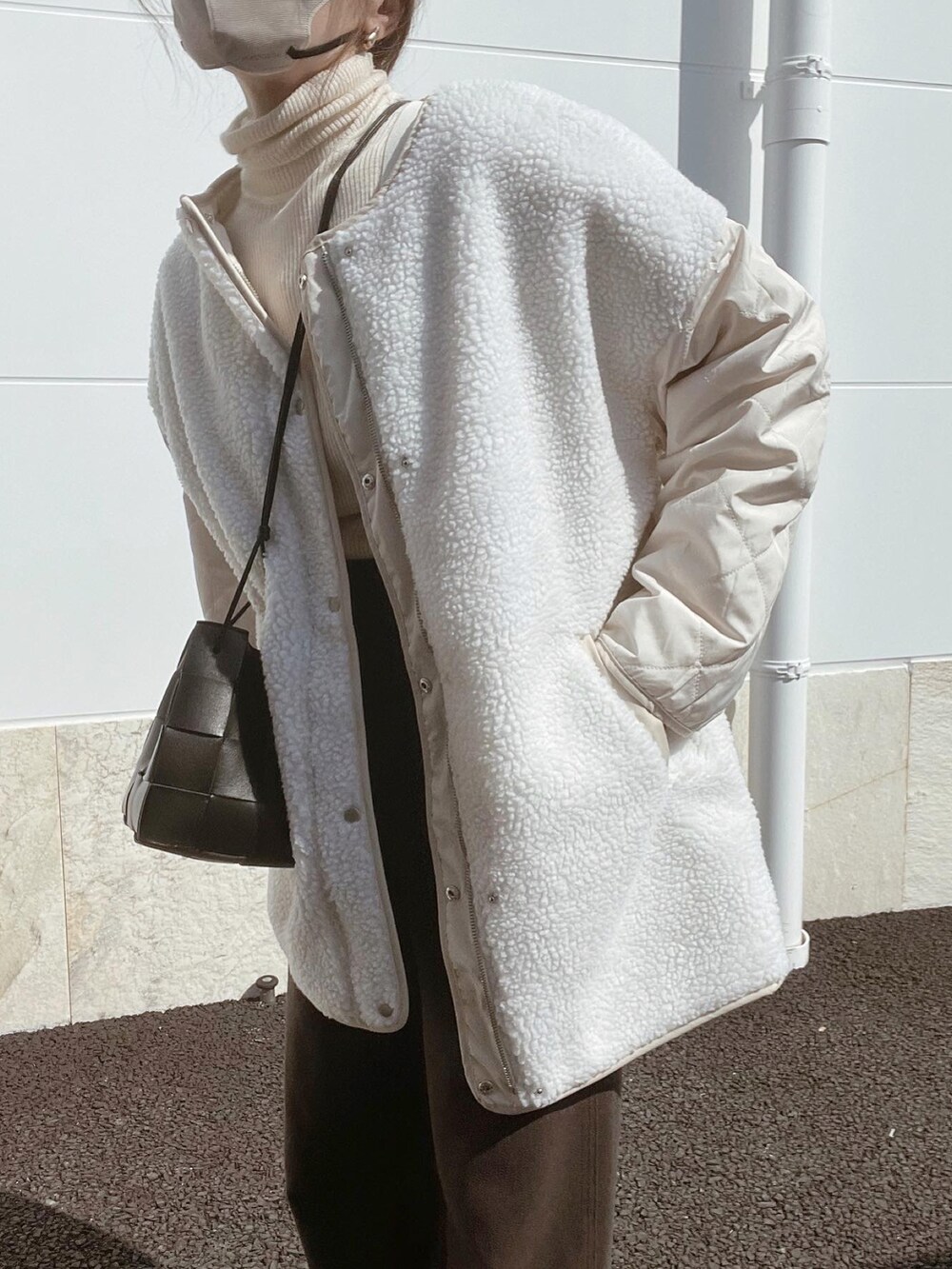 ホワイト系のノーカラージャケット、ブラック系のバッグ、ブラウン系のその他パンツを着用したレディースの秋コーディネートの4枚目の写真