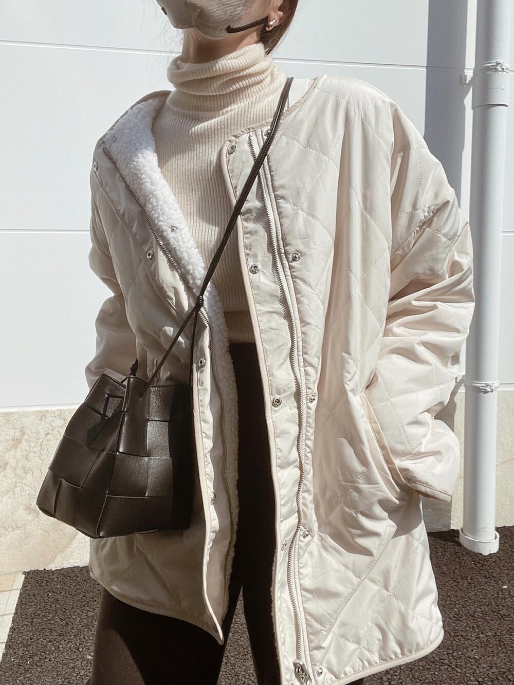 ホワイト系のノーカラージャケット、ブラック系のバッグ、ブラウン系のその他パンツを着用したレディースの秋コーディネートの5枚目の写真