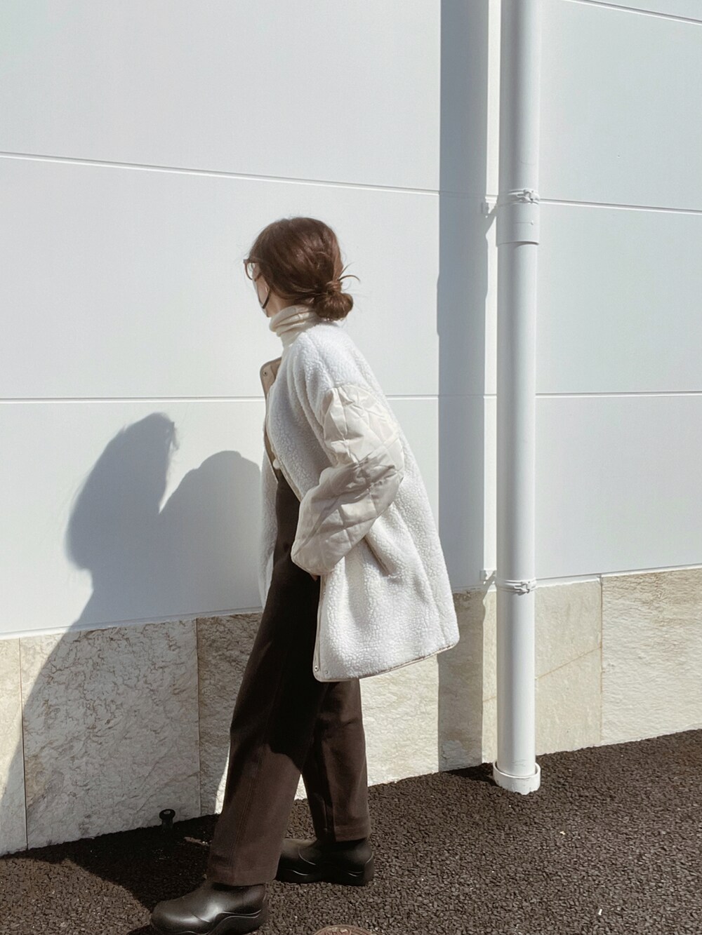 ホワイト系のノーカラージャケット、ブラック系のバッグ、ブラウン系のその他パンツを着用したレディースの秋コーディネートの2枚目の写真