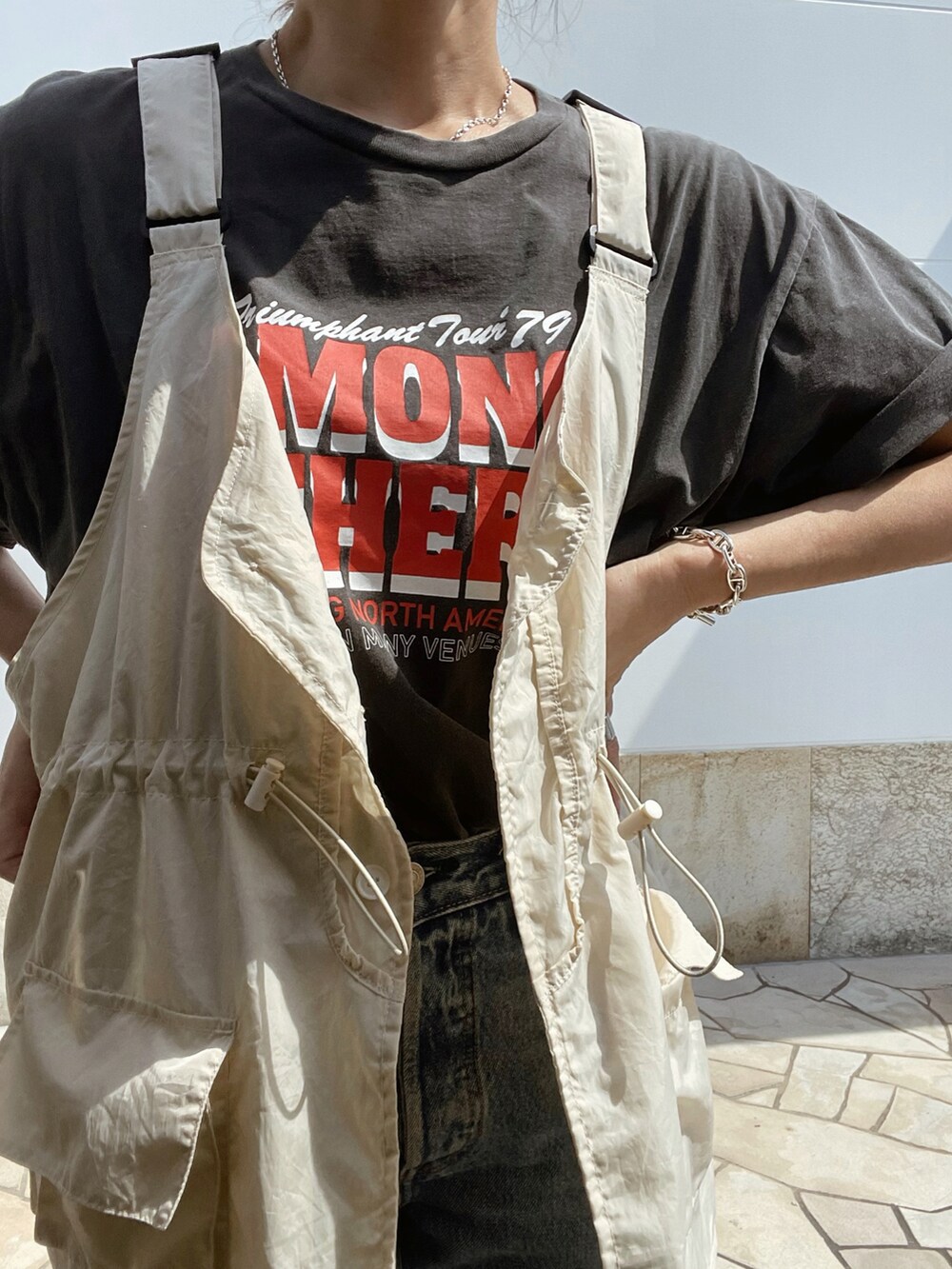 グレー系のTシャツ/カットソー、ブルー系のデニムパンツ、ベージュ系のベストを着用したレディースの夏コーディネートの5枚目の写真