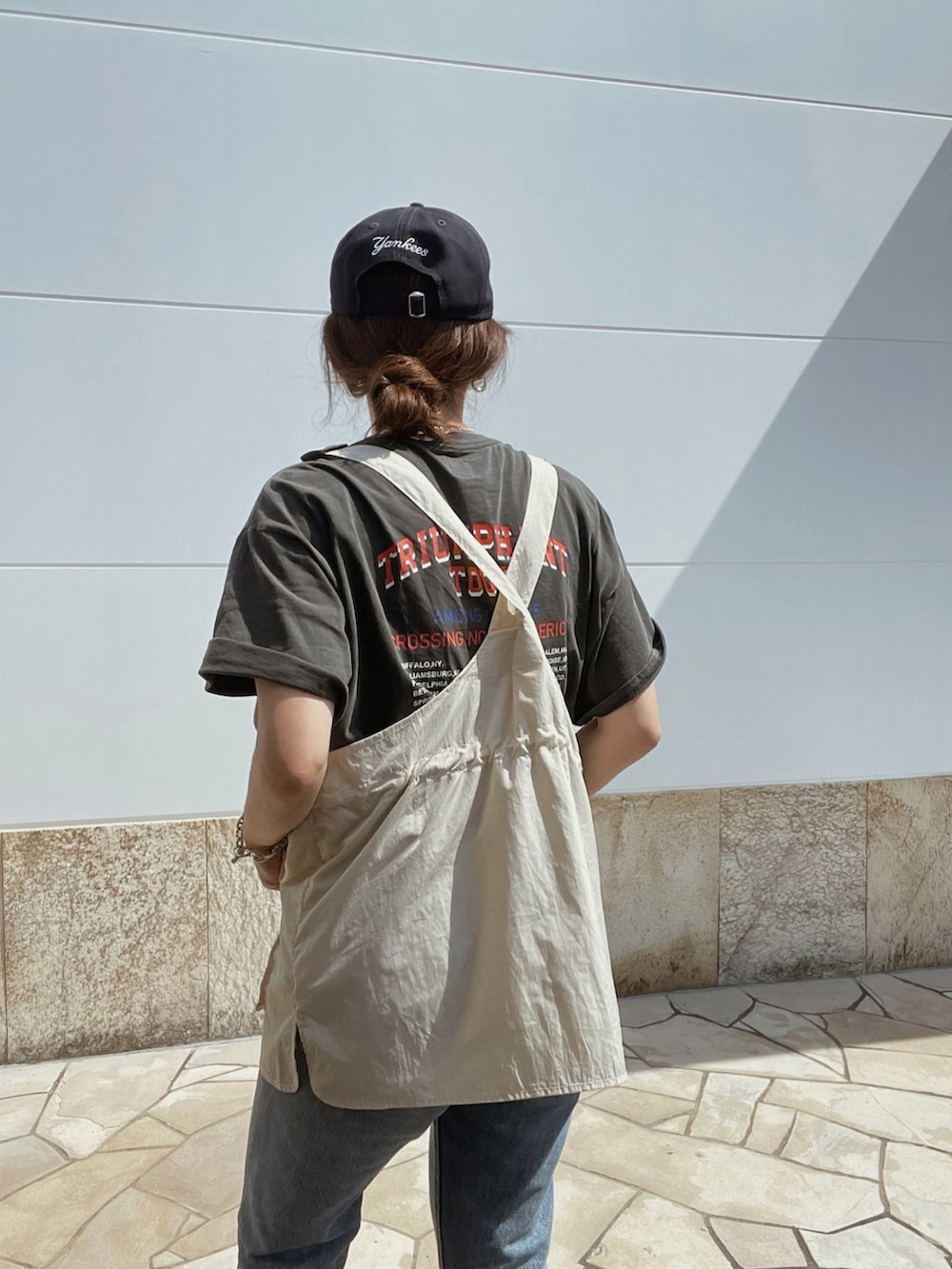 グレー系のTシャツ/カットソー、ブルー系のデニムパンツ、ベージュ系のベストを着用したレディースの夏コーディネートの3枚目の写真