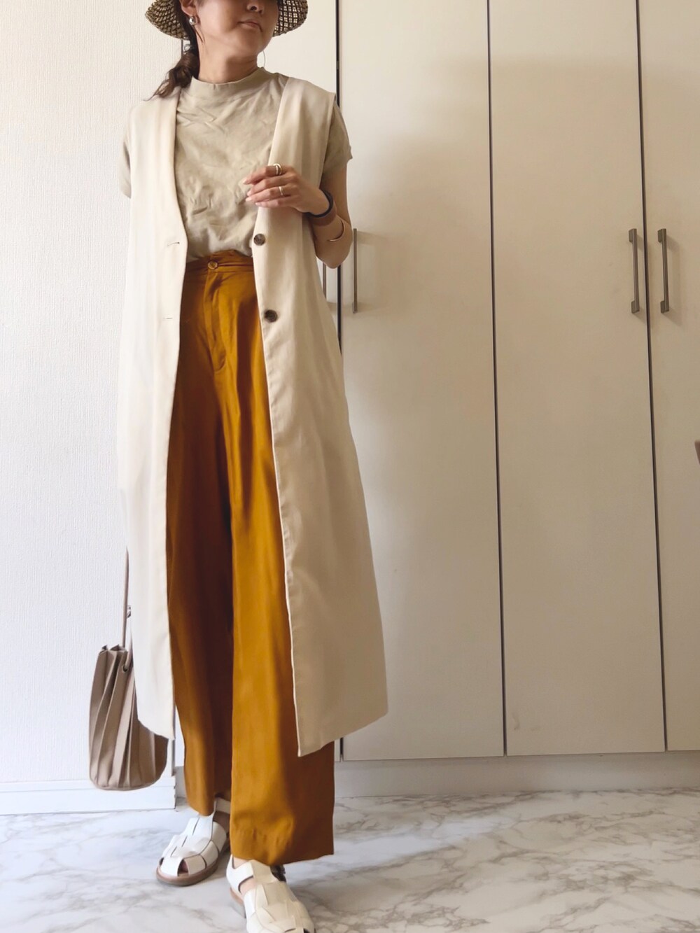 ベージュ系のベスト、ベージュ系のTシャツ/カットソー、イエロー系のその他パンツを着用したレディースの夏コーディネートの2枚目の写真