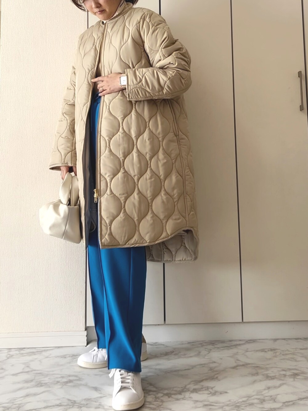 ベージュ系のその他アウター、ベージュ系のニット/セーター、ブルー系のその他パンツを着用したレディースの冬コーディネートの3枚目の写真