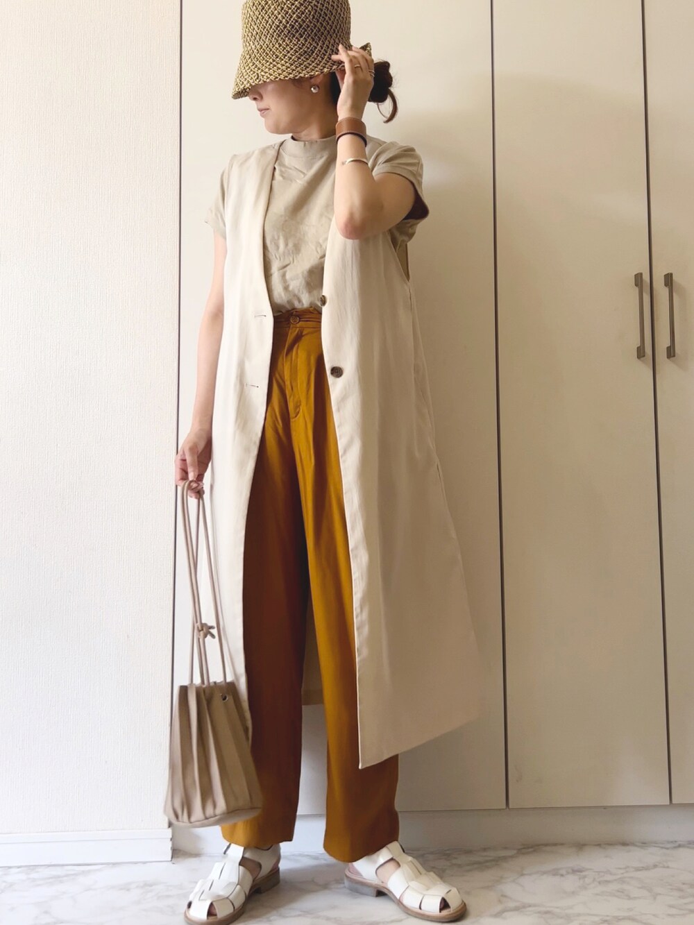ベージュ系のベスト、ベージュ系のTシャツ/カットソー、イエロー系のその他パンツを着用したレディースの夏コーディネートの3枚目の写真