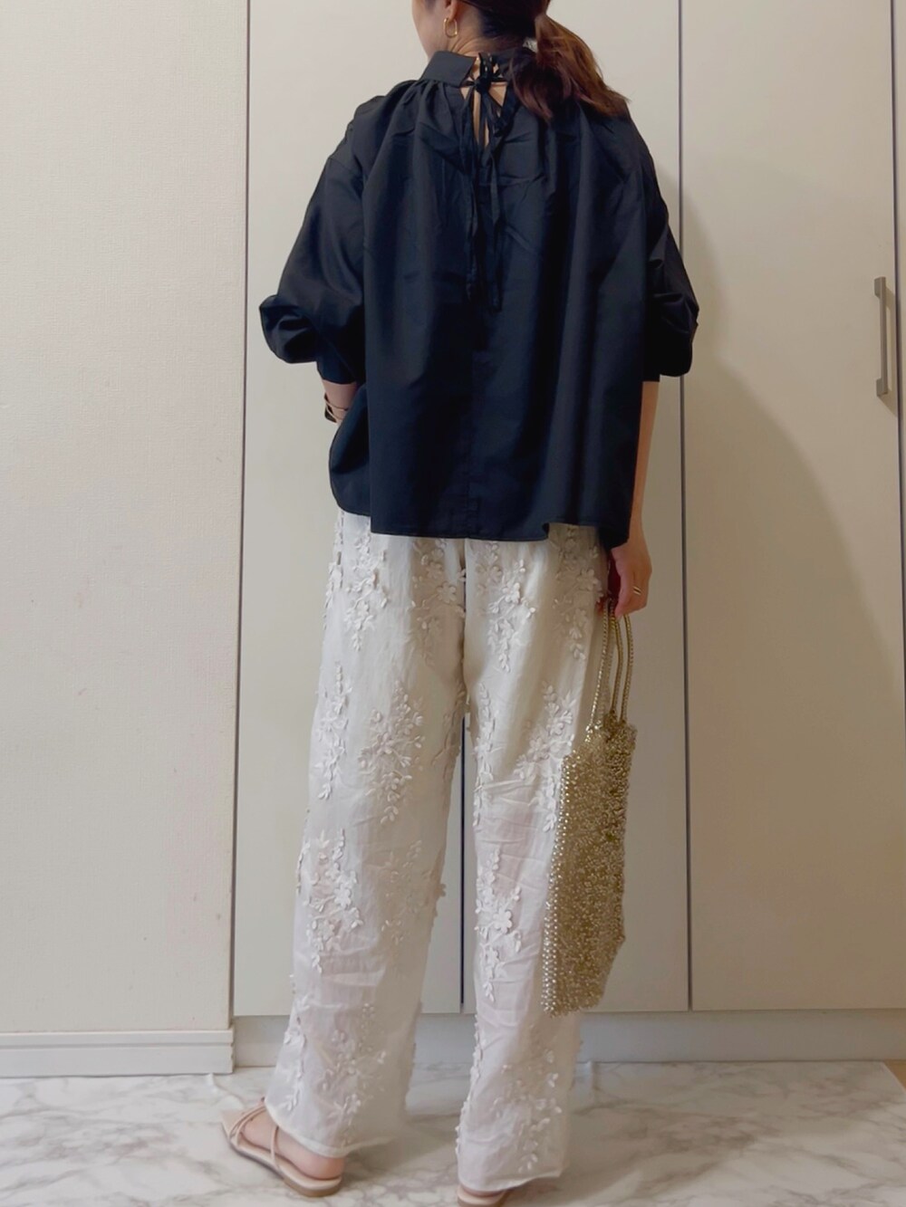 ブラック系のシャツ/ブラウス、ホワイト系のその他パンツ、シルバー系のバッグを着用したレディースの春コーディネートの2枚目の写真