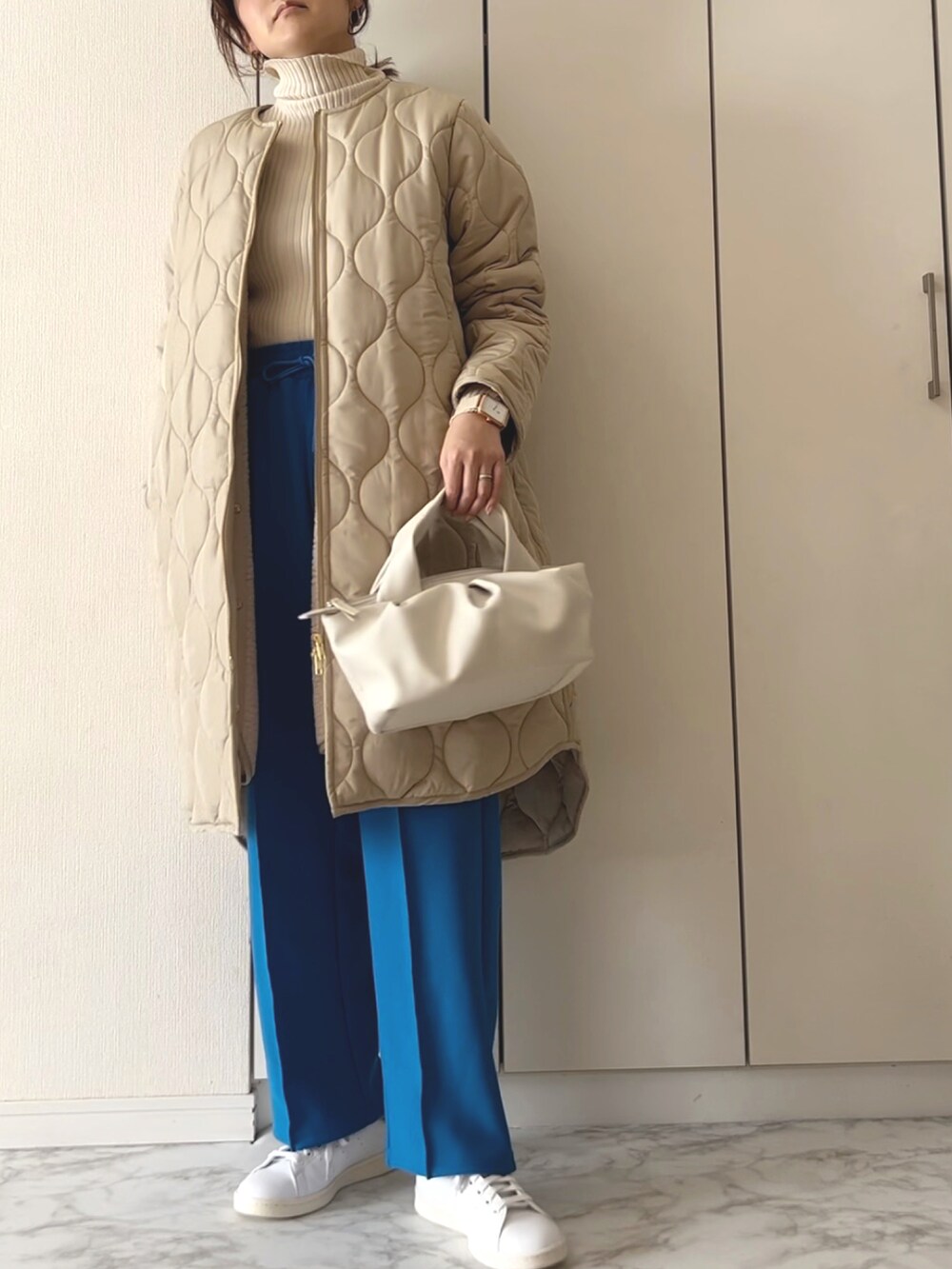 ベージュ系のその他アウター、ベージュ系のニット/セーター、ブルー系のその他パンツを着用したレディースの冬コーディネートの2枚目の写真