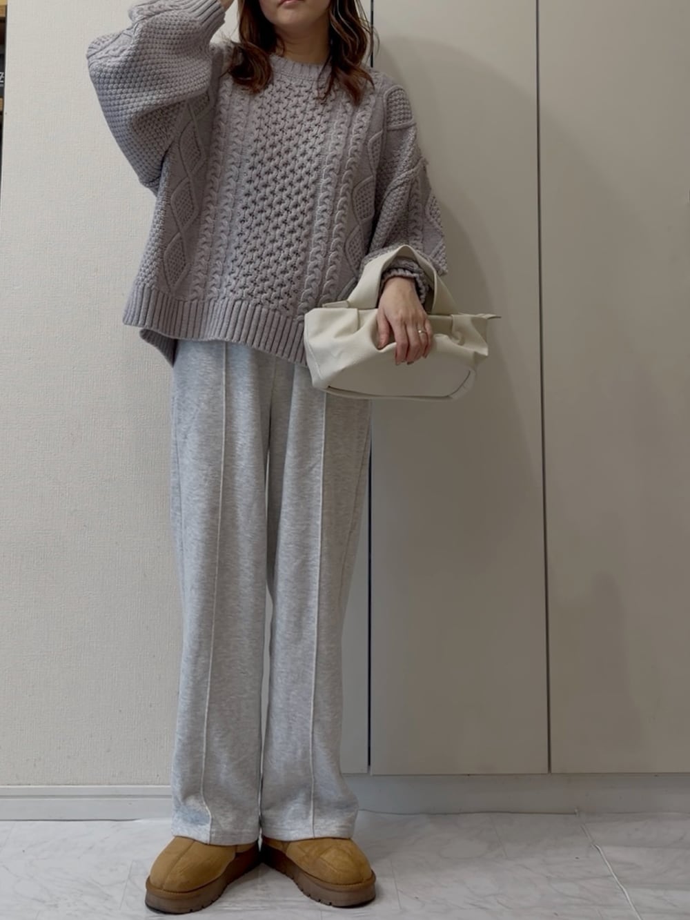 グレー系のニット/セーター、イエロー系のスニーカーを着用したレディースの冬コーディネートの2枚目の写真