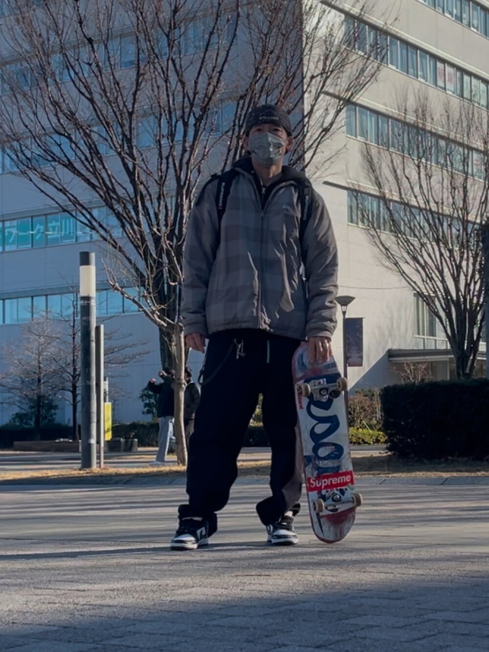 シルバー系のブルゾン、パープル系のスニーカー、ブラック系のパーカーを着用したメンズの冬コーディネートの2枚目の写真