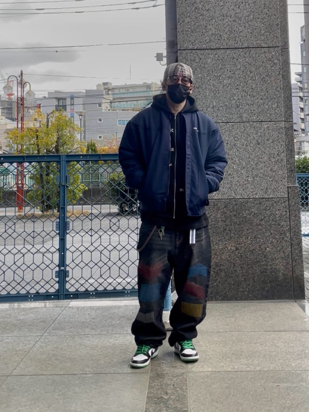 ブルー系のブルゾン、ブラック系のパーカー、ブラック系のデニムパンツを着用したメンズの春コーディネートの3枚目の写真
