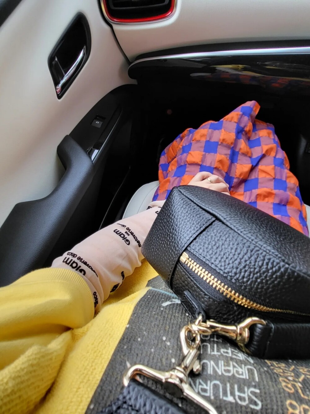 ブラック系のショルダーバッグ、イエロー系のスウェット、オレンジ系のスカートを着用したレディースの秋コーディネートの2枚目の写真