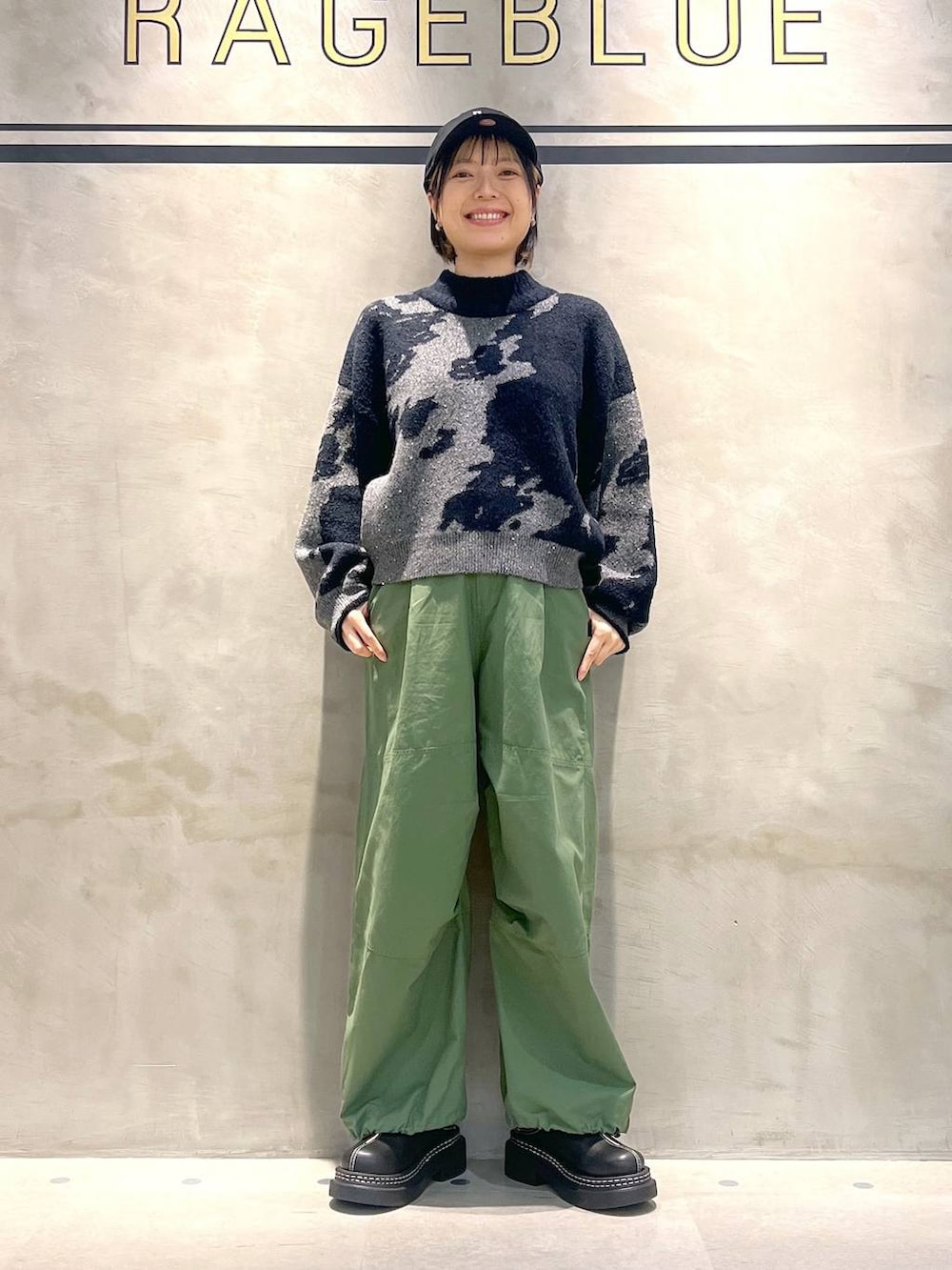 ブラック系のローファー、グリーン系のカーゴパンツ、ブラック系のニット/セーターを着用したレディースの秋コーディネートの2枚目の写真