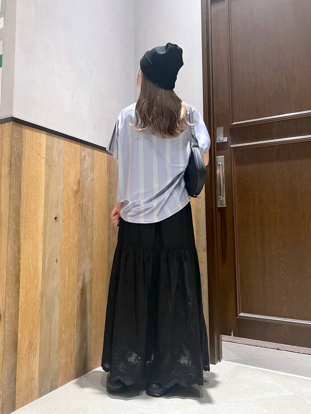 ブラック系のスカート、ブラック系のサンダル、ブルー系のTシャツ/カットソーを着用したレディースの夏コーディネートの3枚目の写真