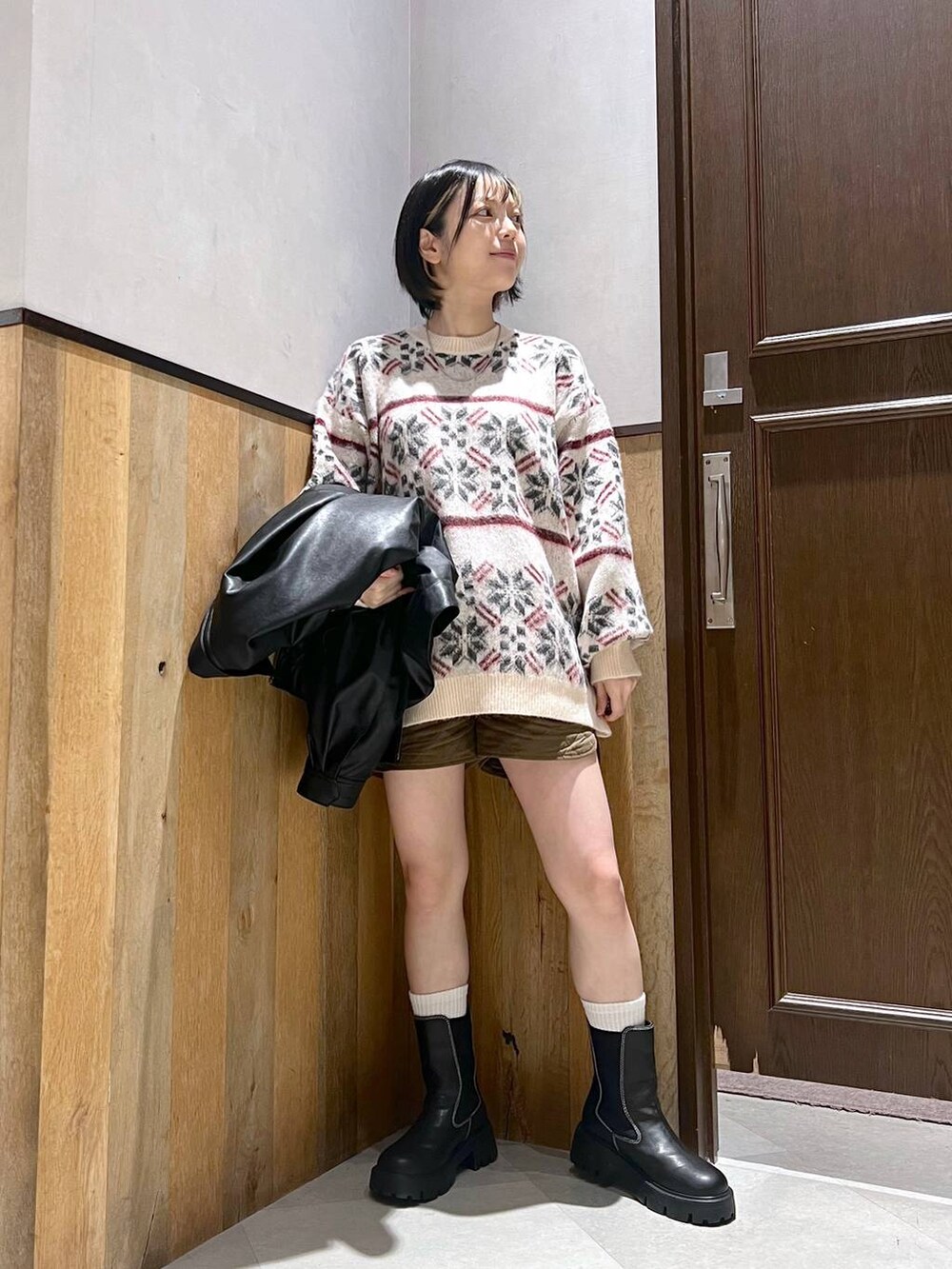 ブラック系のブーツ、ホワイト系のニット/セーター、ブラック系のブルゾンを着用したレディースの秋コーディネートの5枚目の写真
