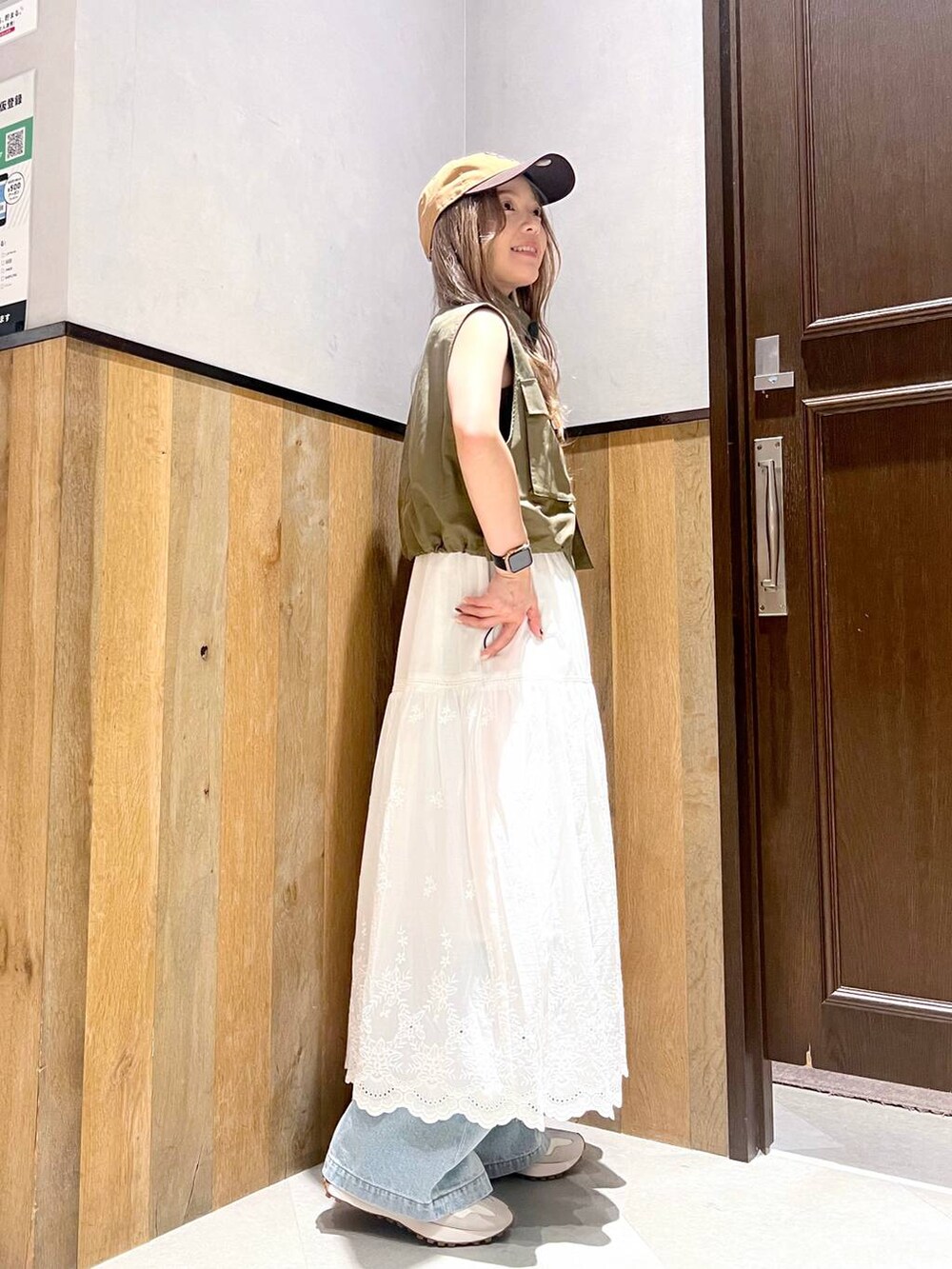 ブルー系のデニムパンツ、ブラック系のキャミソール、ホワイト系のスカートを着用したレディースの夏コーディネートの2枚目の写真