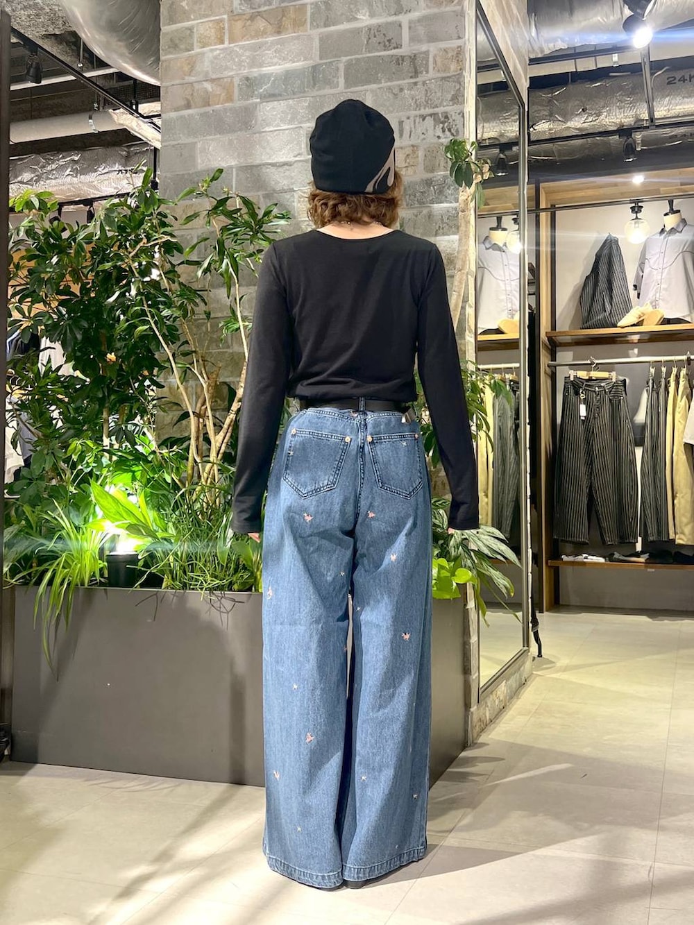 ブルー系のデニムパンツ、ブラック系のTシャツ/カットソー、ブラック系のサンダルを着用したレディースの夏コーディネートの3枚目の写真