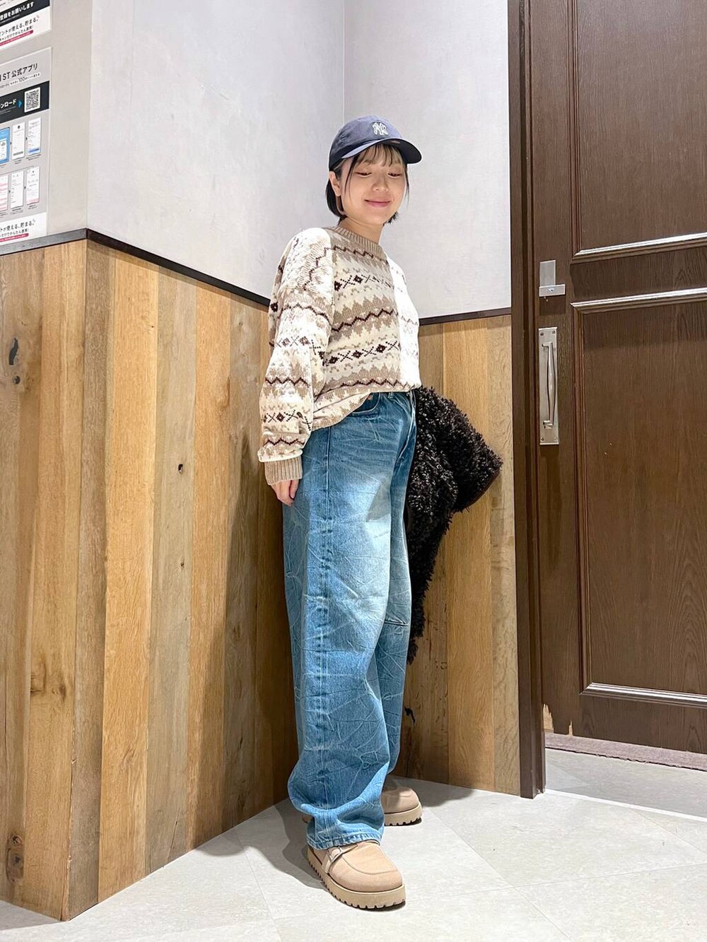 ホワイト系のニット/セーター、ブラウン系のブルゾン、ブルー系のデニムパンツを着用したレディースの秋コーディネートの2枚目の写真