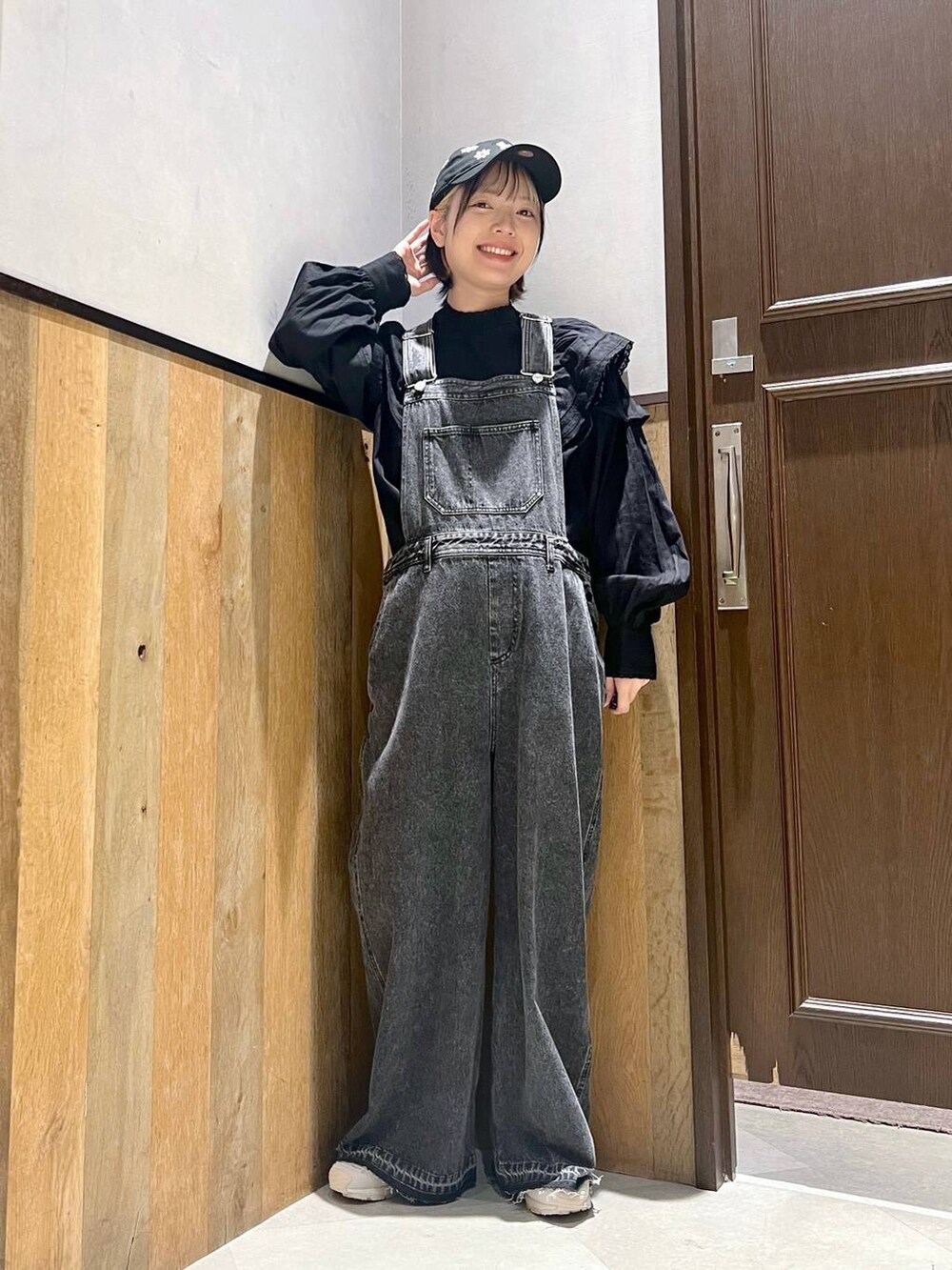 ブラック系のサロペット/オーバーオール、ブラック系のシャツ/ブラウス、グレー系のスニーカーを着用したレディースの秋コーディネートの5枚目の写真