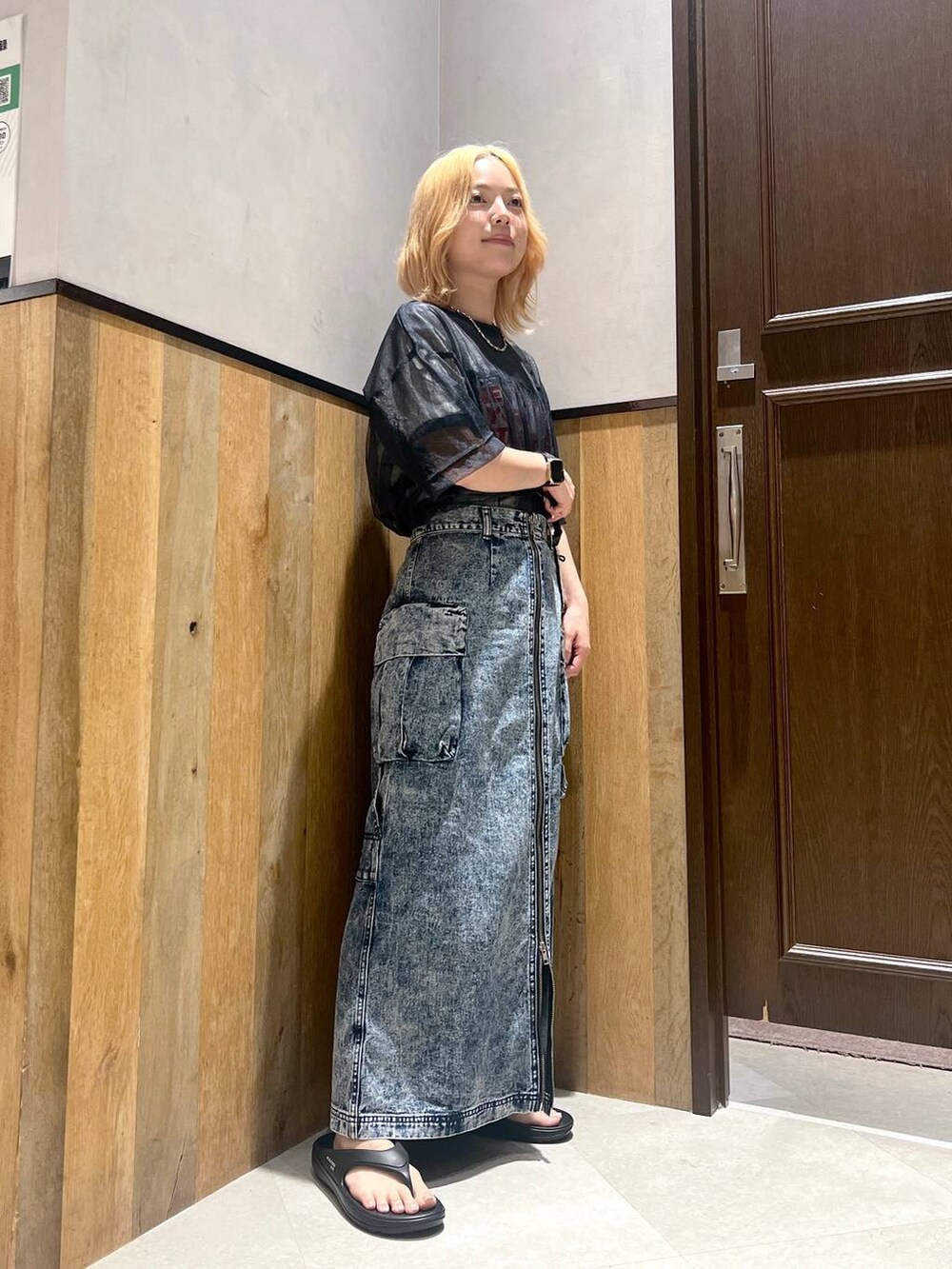 ブラック系のサンダル、ホワイト系のTシャツ/カットソー、ブルー系のデニムスカートを着用したレディースの夏コーディネートの2枚目の写真