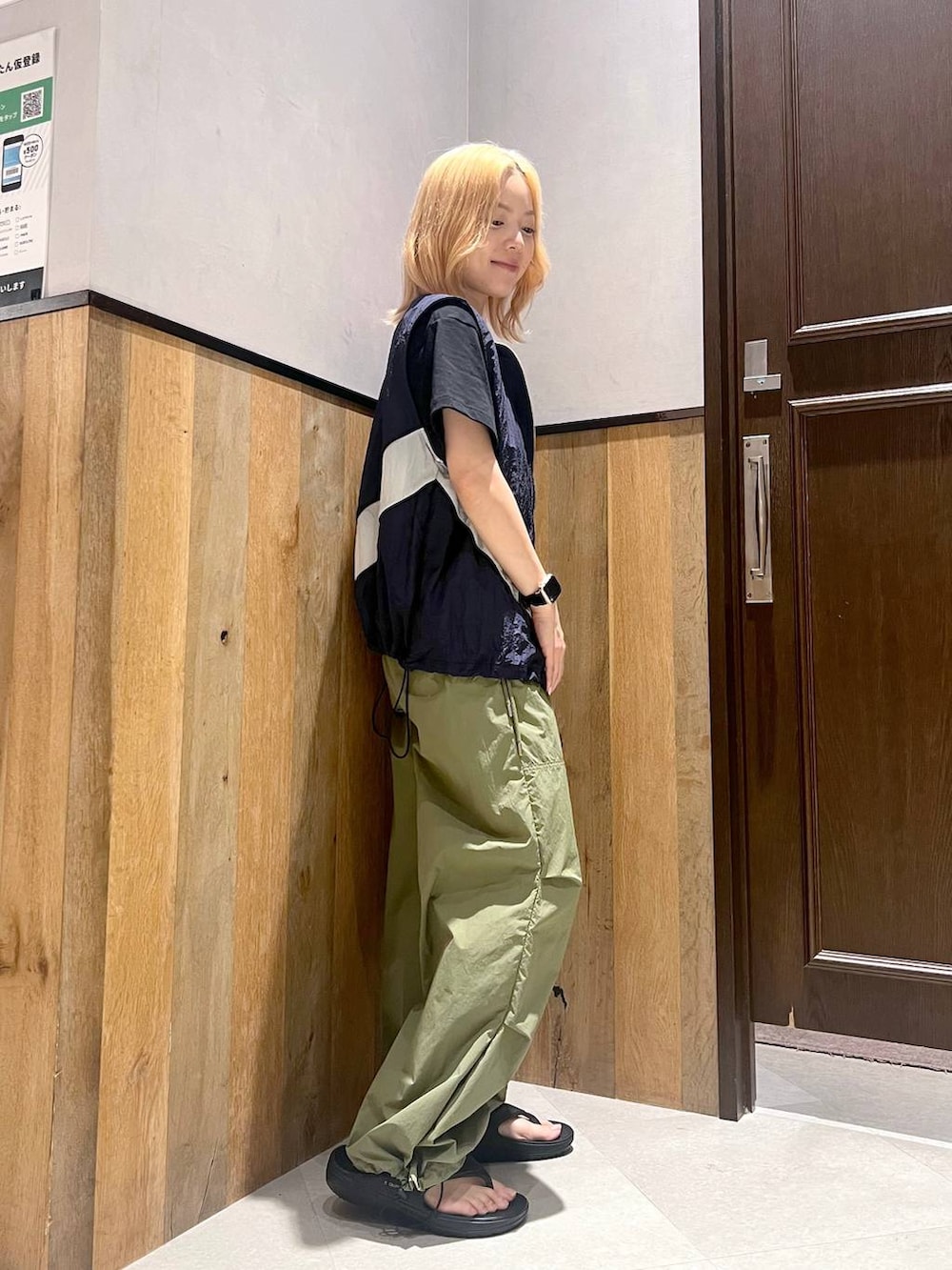 ブラック系のサンダル、ブルー系のベスト、グリーン系のカーゴパンツを着用したレディースの夏コーディネートの3枚目の写真