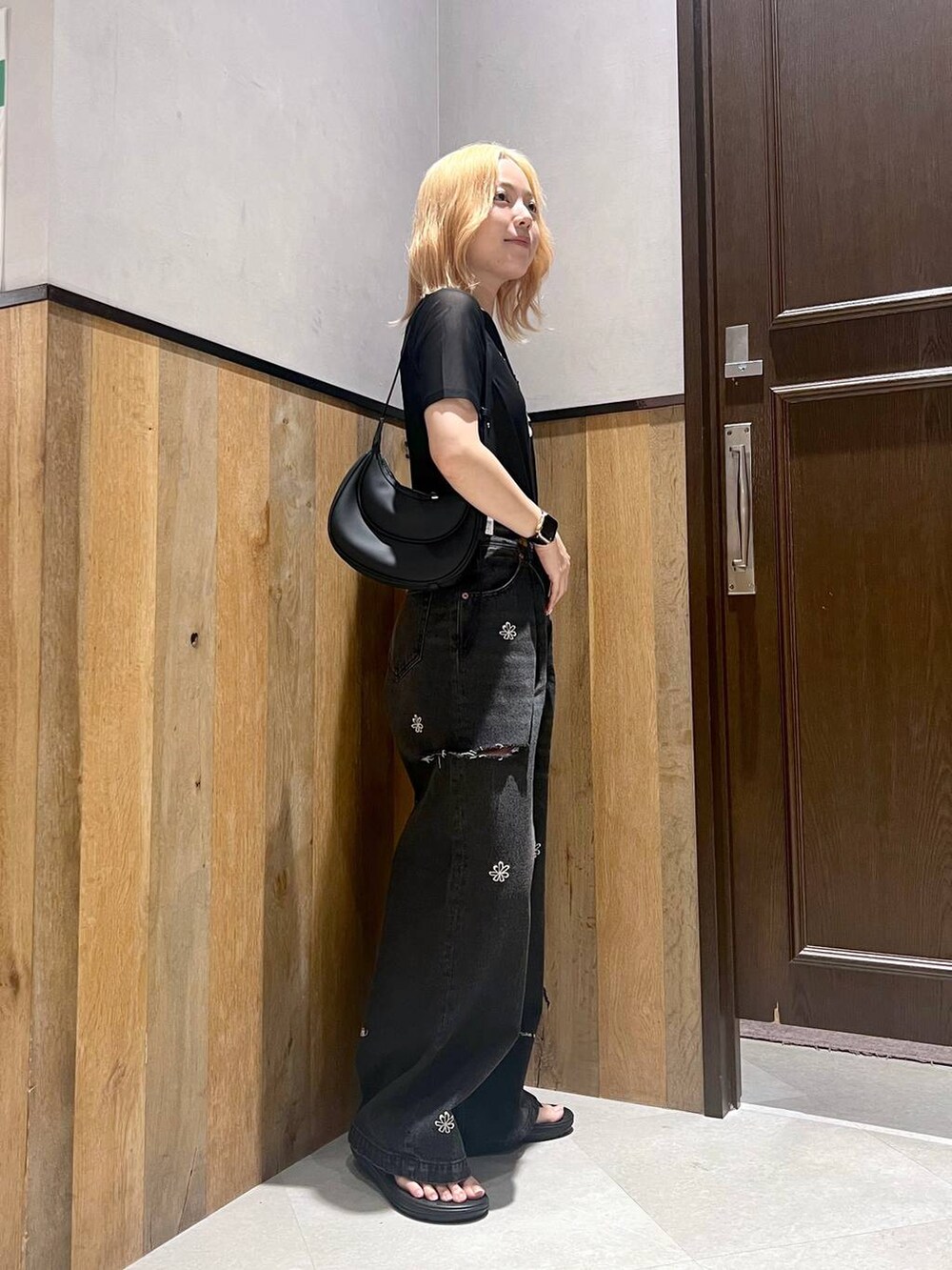 ブラック系のサンダル、ブルー系のデニムパンツ、ブラック系のTシャツ/カットソーを着用したレディースの夏コーディネートの3枚目の写真