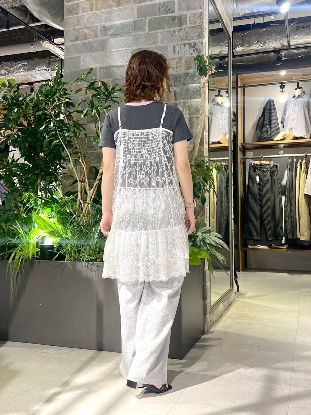 ホワイト系のワンピース、ブラック系のサンダル、グレー系のスウェットパンツを着用したレディースの夏コーディネートの4枚目の写真