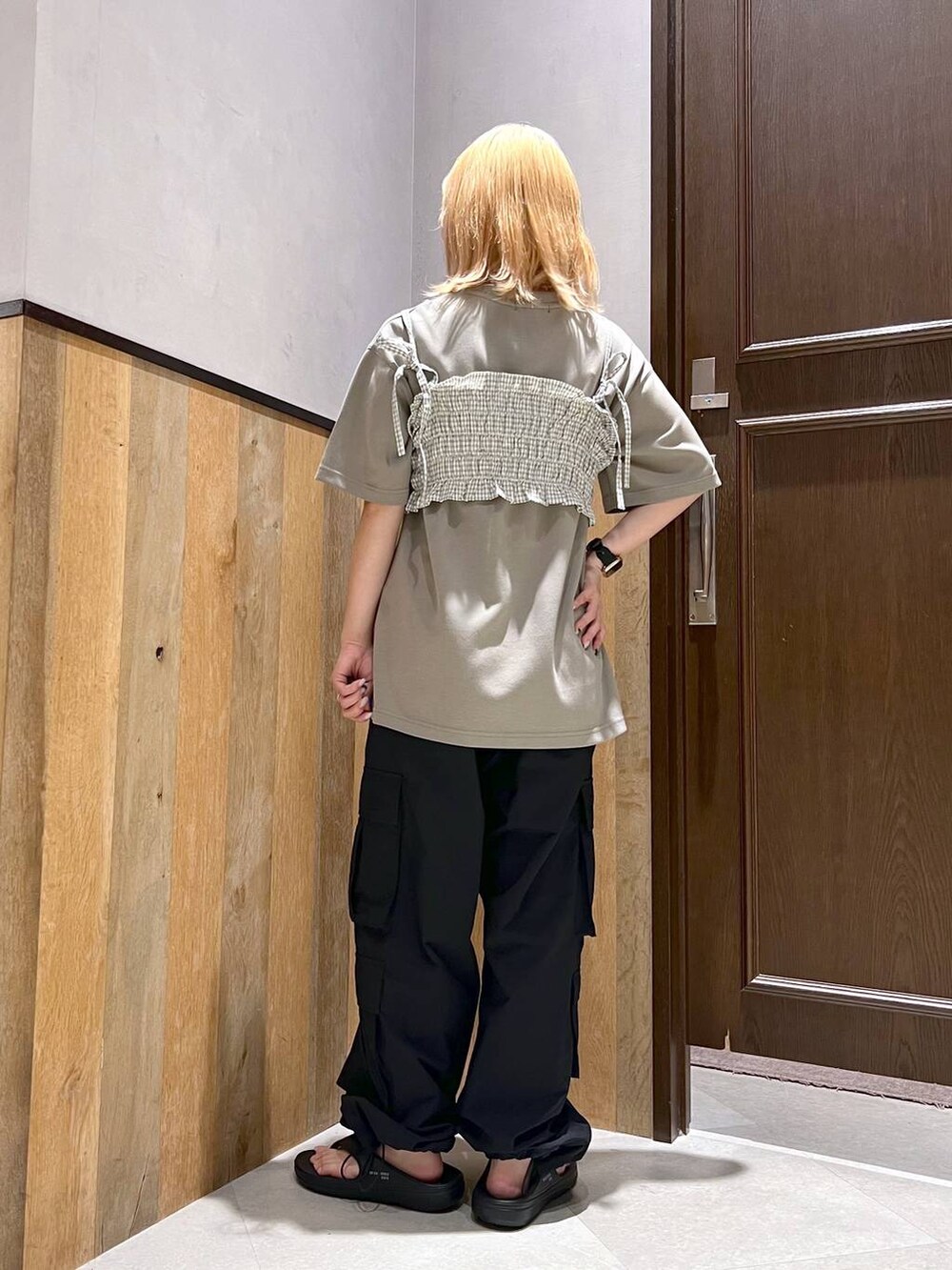 ブラック系のサンダル、ブラック系のカーゴパンツ、ホワイト系のシャツ/ブラウスを着用したレディースの夏コーディネートの3枚目の写真