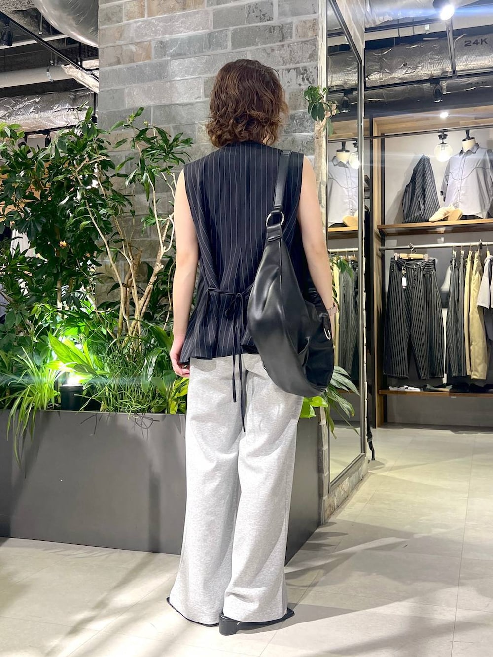 ブラック系のショルダーバッグ、ブラック系のサンダル、グレー系のスウェットパンツを着用したレディースの夏コーディネートの4枚目の写真